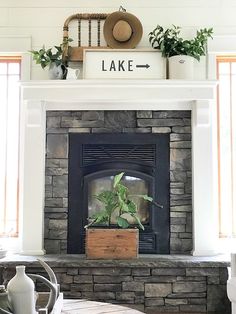 a living room with a fire place and potted plants on the mantel above it