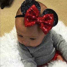 a baby wearing a minnie mouse ears headband