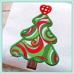 a christmas tree on top of a piece of paper with red and green swirls