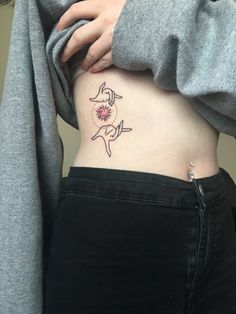 a woman's stomach with a small tattoo on the side of her belly,