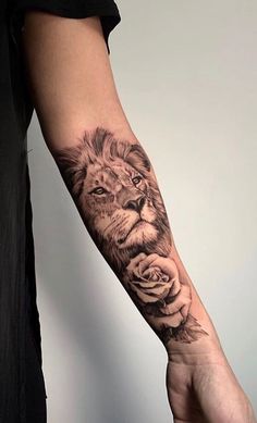 a man's arm with a lion and rose tattoo on the left side of his arm