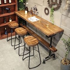 three wooden stools sitting next to a long table