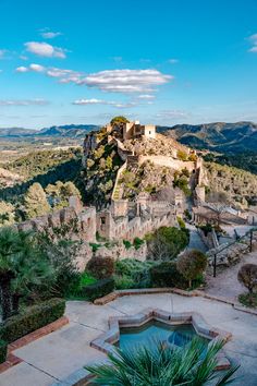 an old castle sits on top of a hill