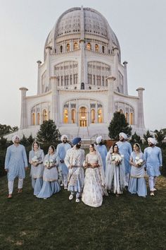 a group of people standing in front of a large building with a dome on top