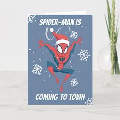 a spiderman is coming to town card with snowflakes and flowers in the background