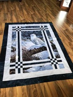 a quilt on the floor with an owl sitting on it