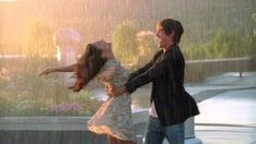 a man and woman dancing in the rain