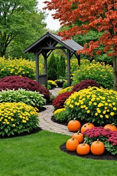 a garden filled with lots of flowers and pumpkins next to a pergolated gazebo