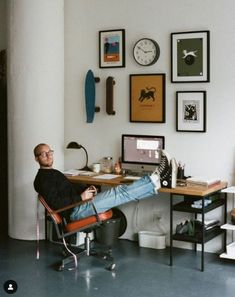 a man sitting at a desk with his feet up on the chair in front of him