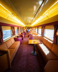 the inside of a train car with couches and tables