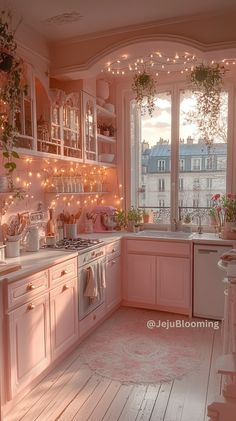 a kitchen with pink cabinets and lights on the windows sill, potted plants hanging over the sink