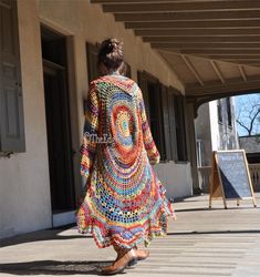 a woman is walking down the sidewalk wearing a colorful dress