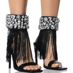 The Azalea Wang " The Rhinestone Draped Tassel Sandal " In Black Is An Open Square Toe Sandal Featuring A Faux Leather Upper, A Cushioned Faux Leather Midsole, A Slim Toe Band, And A Stiletto Heel. Complete With A Wide Rhinestone Gemstone-Embellished Ankle Band, Tassel Fringe Detailing, And An Easy-Open Velcro Closure. Accent This Pair With A Silky Slip Dress For A Luxe Look. - Open Square Toe - Stiletto Heel - Faux Leather Upper - 4.75” Heel Height Elegant High Heel Sandals With Tassels, Elegant Party Heels With Tassels, Party Tassel Open Toe Heels, High Heel Tassel Party Sandals, Party Heels With Tassels And Open Toe, Party Open Toe Heels With Tassels, High Heel Tassel Sandals For Party, High Heel Sandals With Tassels For Party, Glamorous Evening Heels With Rhinestone Fringe