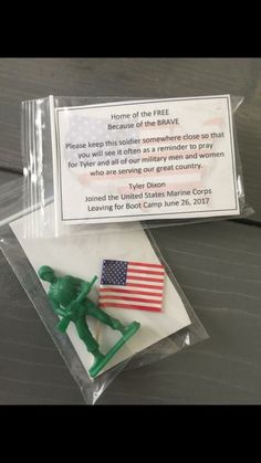 a small plastic toy soldier with an american flag on it's lap, in a clear package