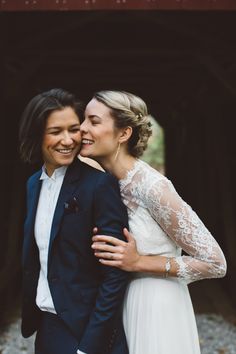 two people standing next to each other in front of a tunnel and smiling at the camera