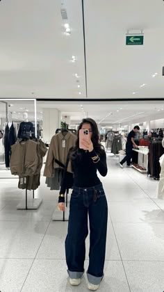 a woman taking a selfie in a clothing store