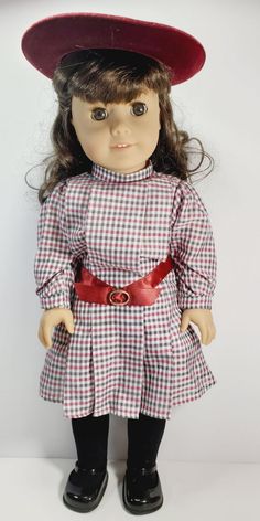 a doll wearing a red hat and dress