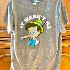 New With Tags Pinocchio “It Wasn’t Me” Short Sleeve Shirt. Picture Of Pinocchio’s Nose Growing #Disney #Pinocchio #Disneyspinocchio #Pinocchiovideo Gray Graphic Tee With Character Print, Gray Cotton Tops With Character Print, Casual Gray Tops With Character Print, Disney Pinocchio, Winnie The Pooh Shirt, Mickey Shirt, Mickey Mouse T Shirt, Mickey Mouse Shirts, Vintage Winnie The Pooh