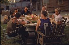 a group of people sitting around a table outside