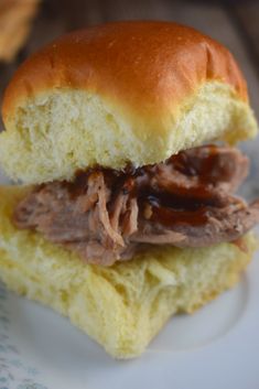 a close up of a sandwich on a plate with meat and sauce in the middle