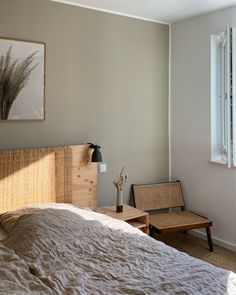 a bed sitting next to a window with a wooden headboard and foot board on top of it