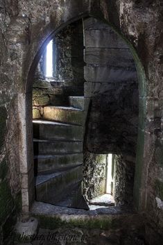 an old stone building with stairs leading up to the light coming in from behind it