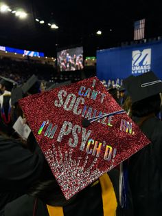 a red graduation cap that says i can't socialize my psychd