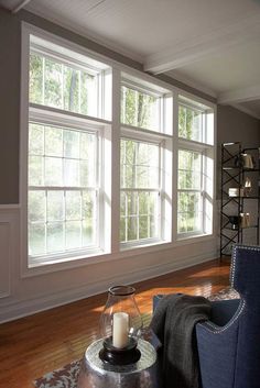 a living room filled with furniture and large windows