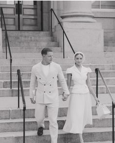 a man and woman are walking down the stairs