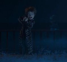 a creepy clown standing in the dark with his hands on his hips and mouth wide open