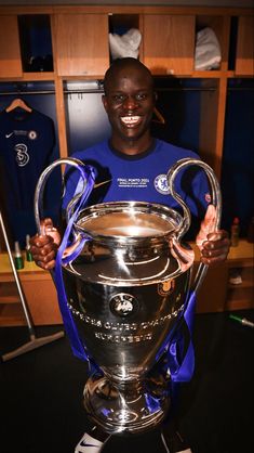 a man holding up a soccer trophy in his hands