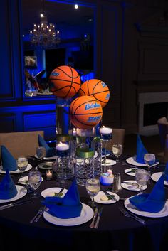 a table topped with plates and cups filled with basketballs on top of it's head