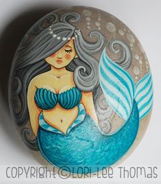 a painted rock with a mermaid on it