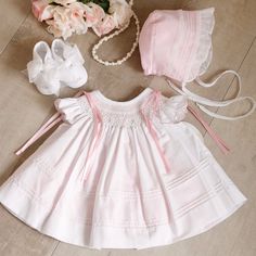 This Little Dress Set Is Most Adorable!! The Set Includes An Heirloom Dress, Slip, Bonnet & Shoes. Smocking, Hand-Embroidery, Satin Ribbons, Pin Tucks And Ruffles Set This Set Apart From The Average Baby Outfit. The Neckline Is Smocked In A Bishop Style And Has Flutter Sleeves That Are Adorned With Pink Dot Embroidery And A Scalloped Embroidered Pink Hem. Embroidered Pink Bullion Buds And Green Leaves Are Super Sweet Atop The Lattice Design Smocking.The Bottom Of The Top Dress Layer Has 8 Row Of White Smocked Dress With Lace Trim For Daywear, White Lace Trim Smocked Dress For Daywear, Cute White Smocked Dress For Baptism, Cute White Smocked Dress For Daywear, Heirloom Bonnet, White Smocked Dress, Baby Pink Clothes, Dot Embroidery, Baby Heirloom