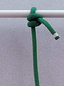 a green rope is attached to a white pole