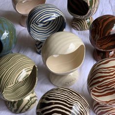 many different bowls sitting on top of a white cloth covered table with zebra print designs