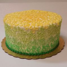 a yellow and green cake sitting on top of a table