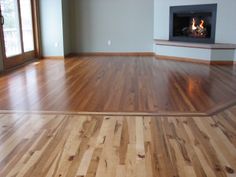 an empty living room with wood floors and a fire place