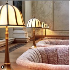 two lamps are sitting next to each other in a room with marble walls and flooring