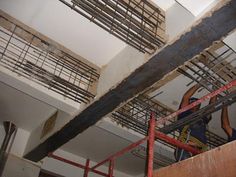 a man standing on top of a wooden stair case next to a metal hand rail