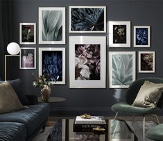 a living room filled with lots of pictures on the wall above a blue couch and coffee table