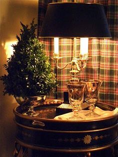 a table topped with a lamp next to a potted plant