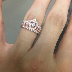 a close up of a person's hand with a diamond ring on their finger