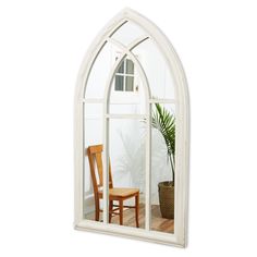 an arched window with a chair and potted plant