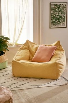 a living room filled with lots of furniture next to a potted plant on top of a hard wood floor