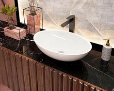 a white bowl sink sitting on top of a black counter next to a wall mounted faucet