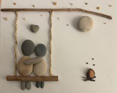 there is a wall decoration made out of rocks and wood with a frog sitting on it