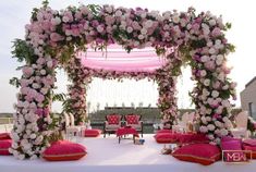 an outdoor wedding setup with pink and white flowers