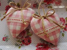 two heart shaped candy bags tied with twine on top of a floral table cloth