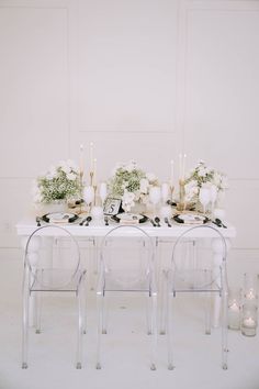 the table is set with candles, flowers and greenery for an elegant wedding reception